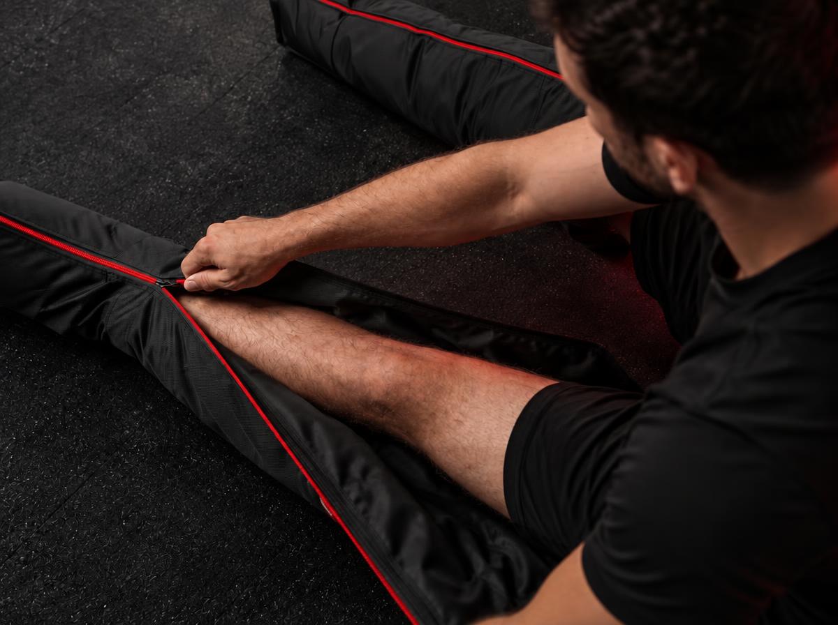 Athlete zipping a Revvive boot around his leg